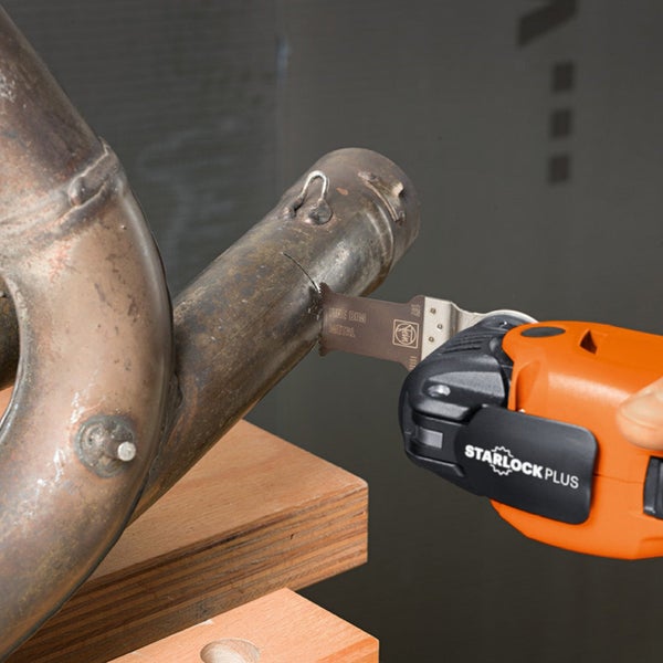 Oszillierendes Multifunktionswerkzeug beim Schneiden eines Metallrohrs.