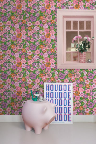 Raumansicht mit floraler Tapete, Fenster, Dekorationen und einem Schwein als Dekoelement.