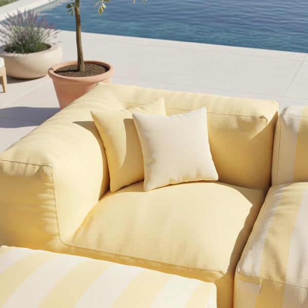 Gelb-weiß gestreifter Outdoorsessel auf einer hellen Terrasse mit Glasgeländer und Poolbereich.