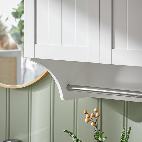 Detailansicht eines weißen Badezimmerschranks mit Handtuchhalter aus Metall.