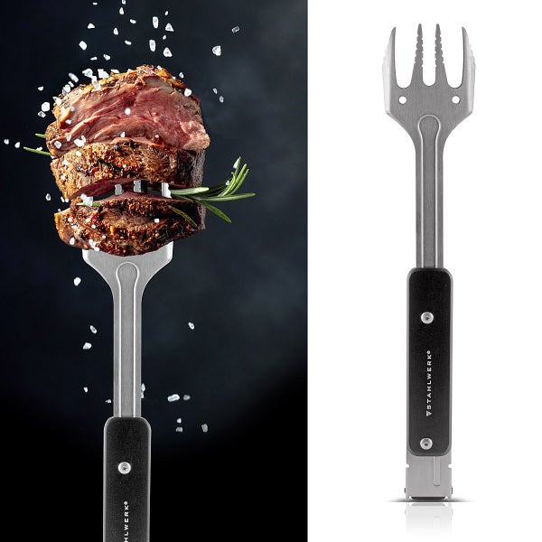 Grillgabel aus Edelstahl mit vier Zinken und schwarzem Griff, ein Steak ist auf die Gabel aufgespießt, Stahlwerk Logo.