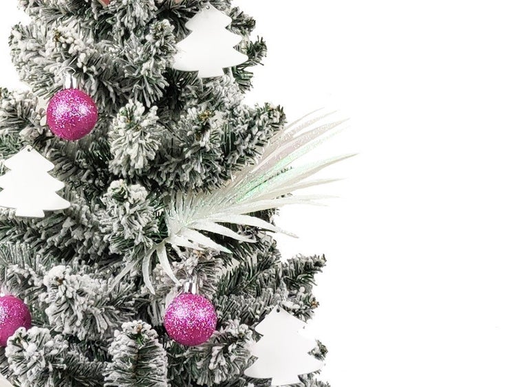 Künstlicher Weihnachtsbaum, beschneit, geschmückt mit glitzernden Kugeln, Tannenbaum Anhängern und einer Blattdekoration.
