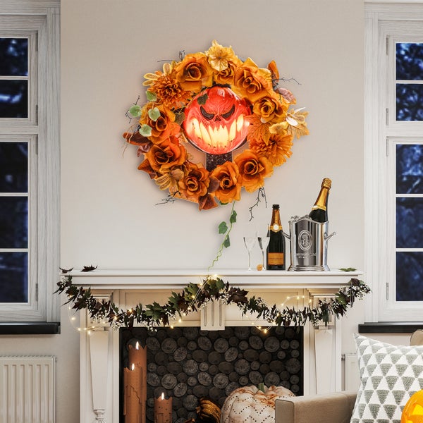 Halloween-Dekoration mit Blumenkranz, Kürbis-Laterne, Girlande und Champagner auf einem Kaminsims.