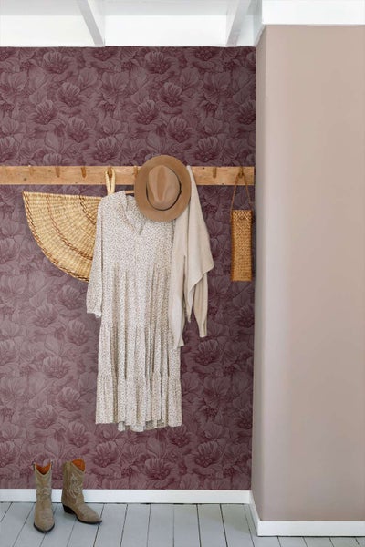 Wandgestaltung im Flur mit florale Tapete und einer hölzernen Garderobe mit Kleidung und Accessoires.