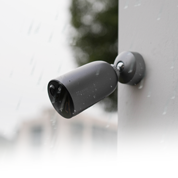 Wetterfeste Überwachungskamera für den Außenbereich an einer Wand montiert im Regen.
