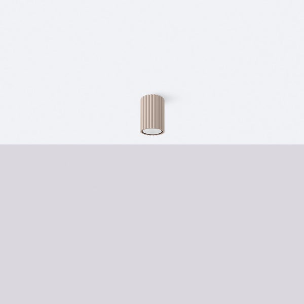 Zylinderförmige Wandleuchte mit geriffelter Oberfläche.