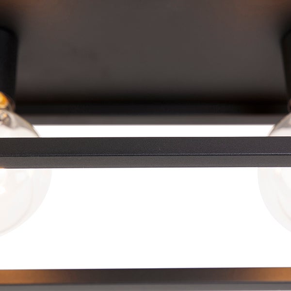 Detailaufnahme einer Deckenleuchte mit rechteckigem Rahmen und Glühbirnen