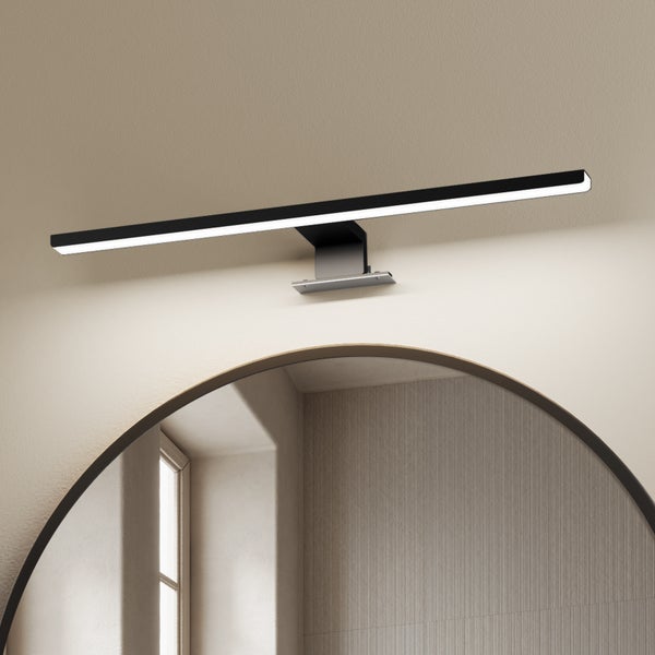 Wandleuchte in Schwarz über einem Spiegel im Badezimmer