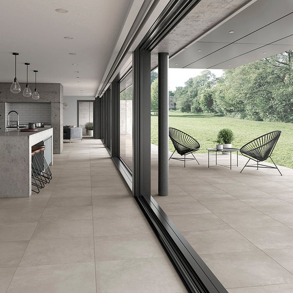 Moderne offene Küche mit großformatigen Bodenfliesen und Übergang zur Terrasse mit Blick auf den Garten.