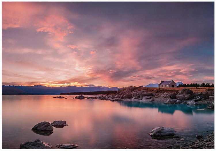 Landschaft mit einem kleinen Gebäude am Ufer eines Sees bei Sonnenuntergang