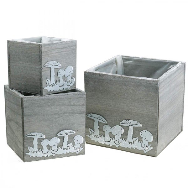 Drei graue Pflanzgefäße aus Holz mit Pilzmotiv