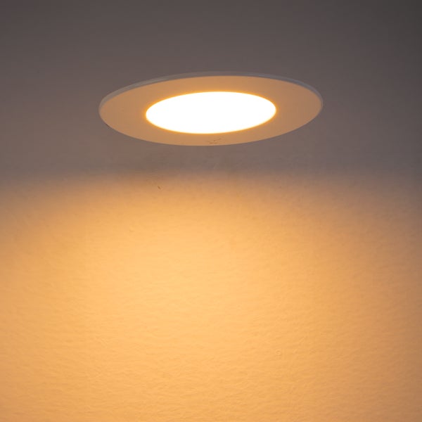 Runder LED-Einbaustrahler im eingeschalteten Zustand mit warmweißem Lichtkegel.