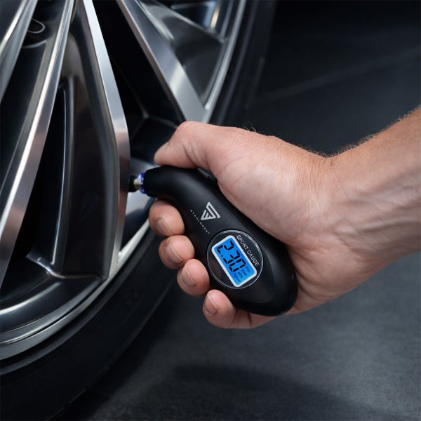 Digitaler Reifendruckprüfer von Stahlwerk am Ventil eines Autoreifens. Display zeigt den gemessenen Druck an. Stahlwerk Logo.