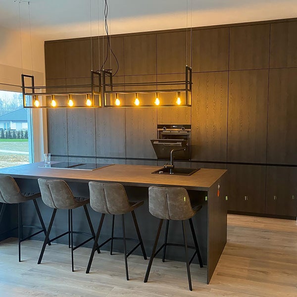 Helle Küche mit Kochinsel, Barhockern und Hängelampe