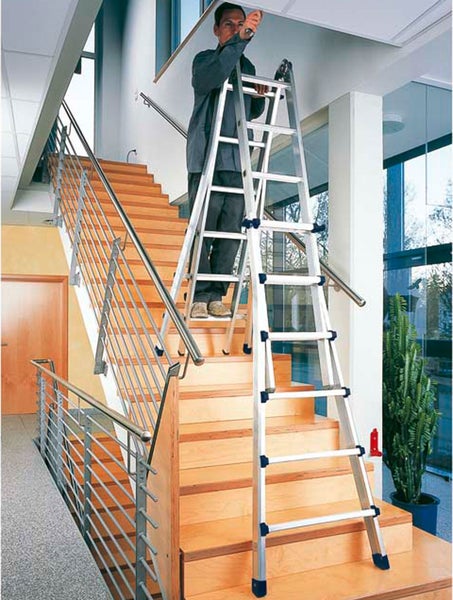 Mann auf einer Mehrzweckleiter im Treppenhaus bei Reparaturarbeiten an der Decke