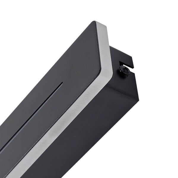 Nahaufnahme eines Details einer rechteckigen Wandleuchte mit schwarzem Gehäuse und lichtdurchlässigem Lichtstreifen.