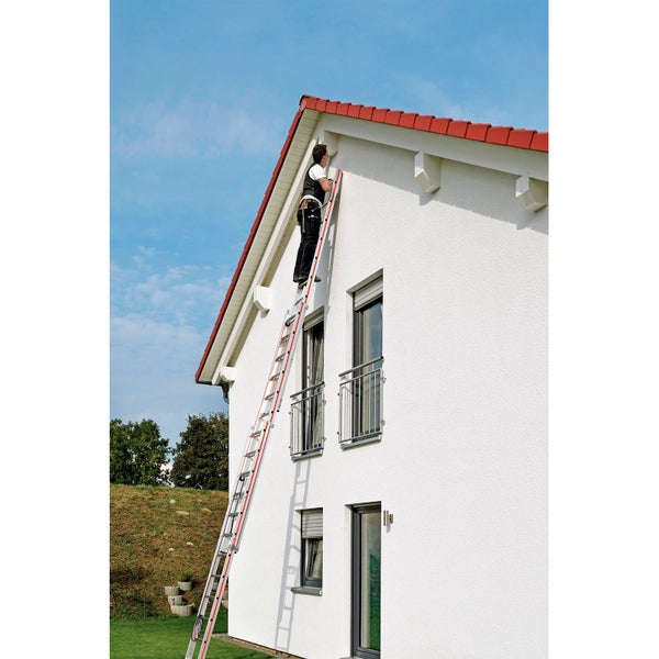 Eine Person steht auf einer Mehrzweckleiter an einer Hauswand.