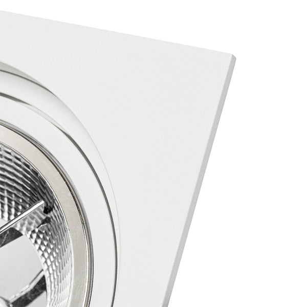 Nahaufnahme eines weißen quadratischen Einbaustrahlers mit strukturiertem Rahmen und rundem Reflektor.