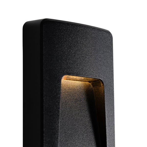 Schwarze, rechteckige Außenleuchte mit strukturierter Oberfläche und warmweißem Licht aus einer zentralen Öffnung.