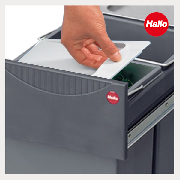 Hand hebt Deckel eines Inneneimers im Hailo Mülltrennsystem mit Auszug an. Hailo Logo.