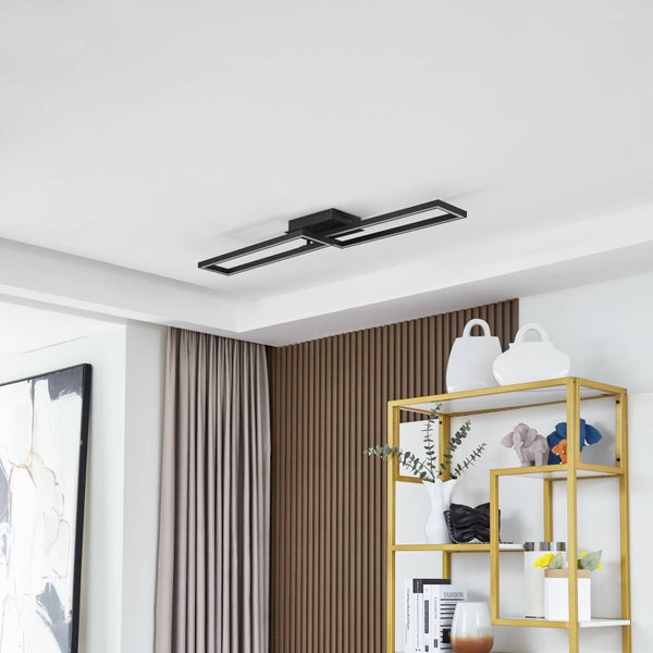 Schwarze LED-Deckenleuchte mit zwei rechteckigen Rahmen in hellem Raum mit Holzlamellenwand und goldenem Regal.
