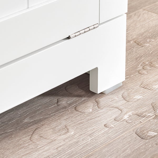 Detailansicht eines weißen Badezimmerschranks mit Wasser auf dem Boden