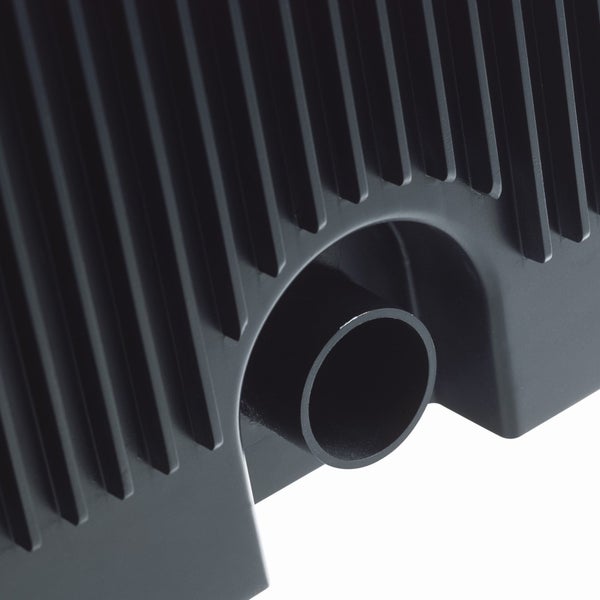 Detailaufnahme eines schwarzen Kunststoffgehäuses mit Lamellenstruktur und rundem Rohranschluss.