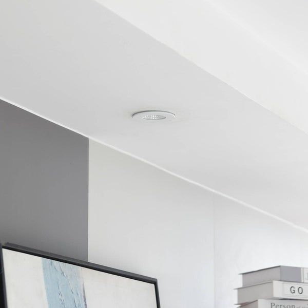 LED-Einbaustrahler in der Decke eines hellen, modern gestalteten Raums mit Büchern und Wandbild.
