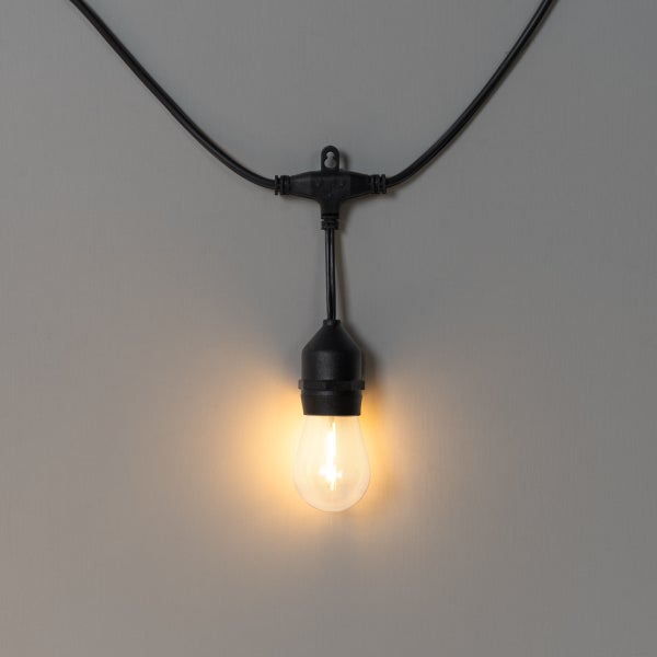 Schwarze LED-Lichterkette mit einer leuchtenden LED-Filament-Lampe in Warmweiß.