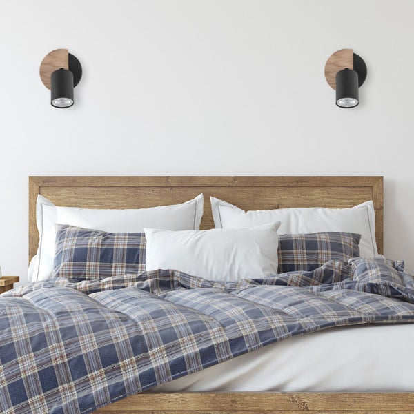 Bett mit karierter Bettwäsche und Wandleuchten