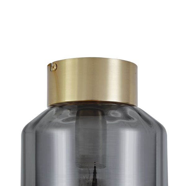 Nahaufnahme einer Rauchglaslampe mit goldener Fassung