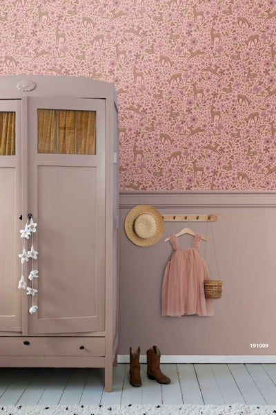 Tapete mit Reh und Blumen Muster in einem Kinderzimmer mit Schrank und Kinderkleidung an der Wand.
