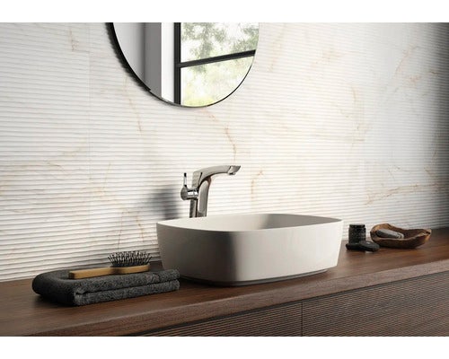 Modernes Badezimmer mit weißem Aufsatzwaschbecken und Chromarmatur auf einer Holzkonsole. Strukturierte Wandfliesen mit Marmoroptik.