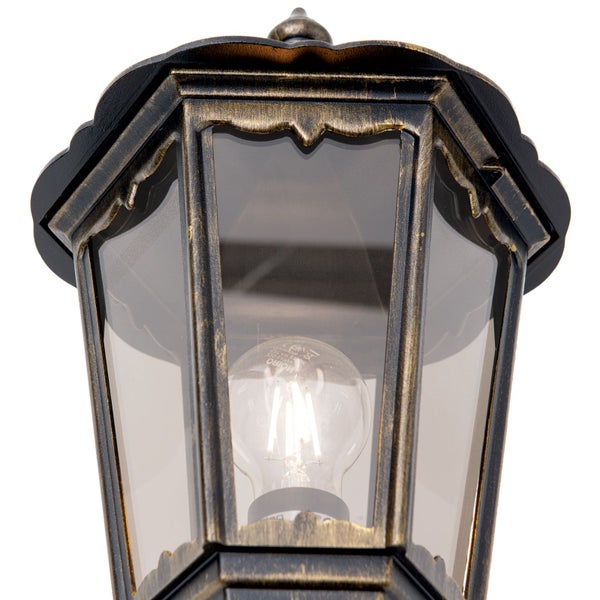 Nahaufnahme einer traditionellen Außenlaterne mit antikem Metallrahmen, Glasscheiben und einem leuchtenden LED-Leuchtmittel.
