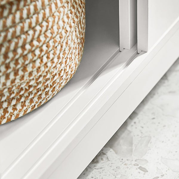 Detailaufnahme eines weißen Regals mit geflochtenem Korb