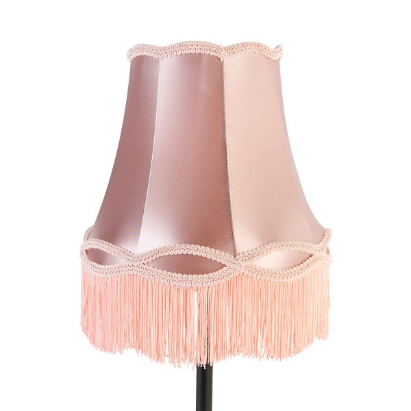 Lampenschirm aus glänzendem Textil in Altrosa mit dekorativer Borte und langen Fransen.