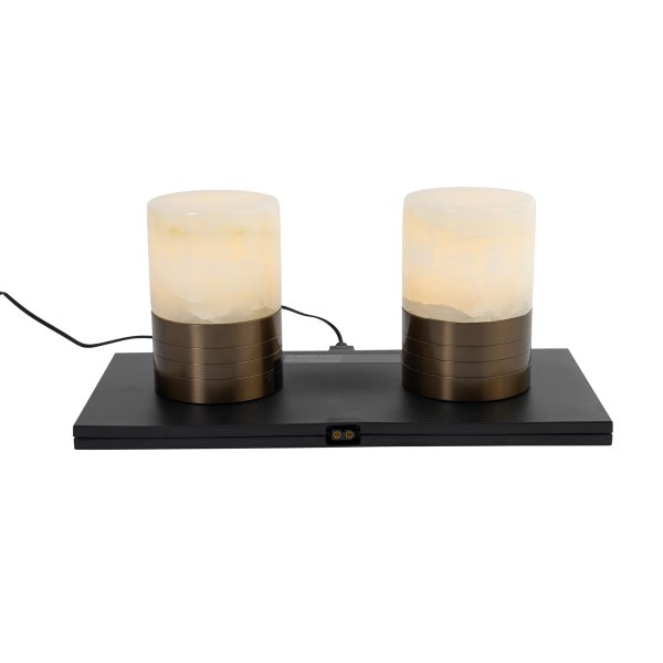 Zwei zylindrische Tischleuchten mit Schirm in Marmoroptik und Metallfuß auf einer schwarzen Ladestation.