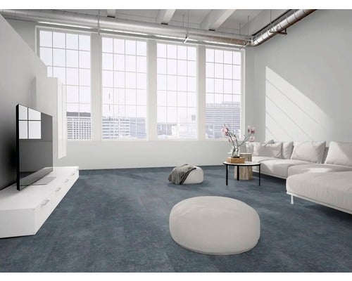 Modernes Wohnzimmer mit dunkelblau-grauem Bodenbelag, großen Fenstern im Industriestil, weißem Sofa und minimalistischen Möbeln. Hell und geräumig.