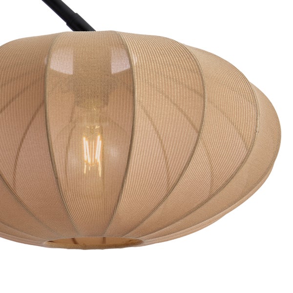 Nahaufnahme eines runden Lampenschirms aus Textilgewebe mit einem sichtbaren Filament-Leuchtmittel im Inneren an einem schwarzen Metallarm.