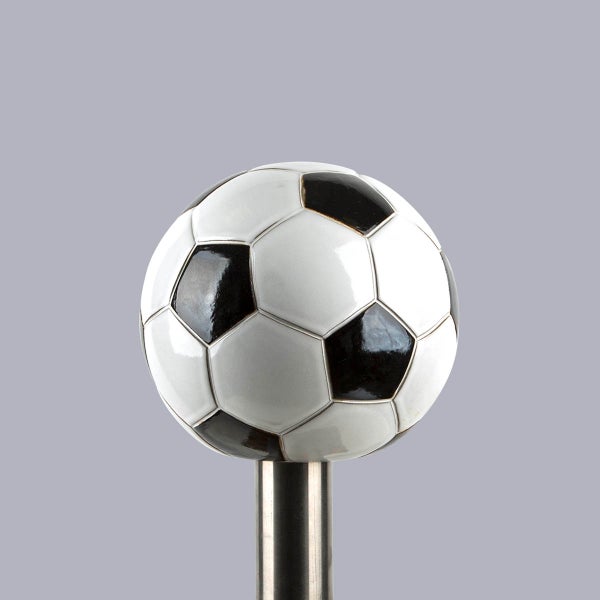 Vorhangstangen-Endstück Fußball aus Keramik auf einem Metallhals.