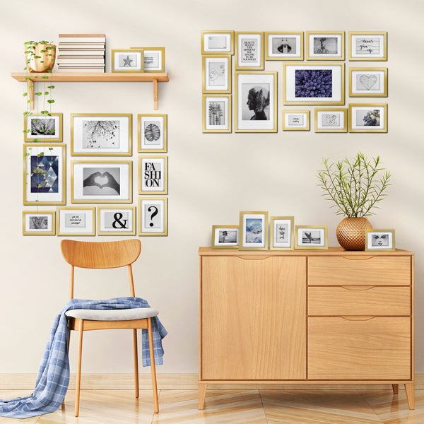 Wohnzimmer Wanddekoration mit zahlreichen goldenen Bilderrahmen in verschiedenen Größen als Fotowand über einem Holzkommode und einem Holzstuhl.