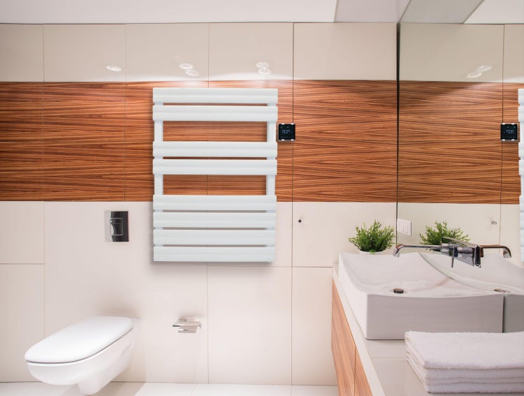 Badezimmer mit Toilette, Waschbecken, Handtuchheizkörper und Spiegel