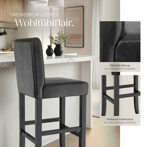 Schwarzer Barhocker mit Rückenlehne und Sitz aus Kunstleder sowie Holzgestell mit Fußstützen in einer modernen, hellen Küche.