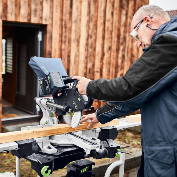 Mann schneidet Holz mit einer Festool Kapex Kapp- und Gehrungssäge
