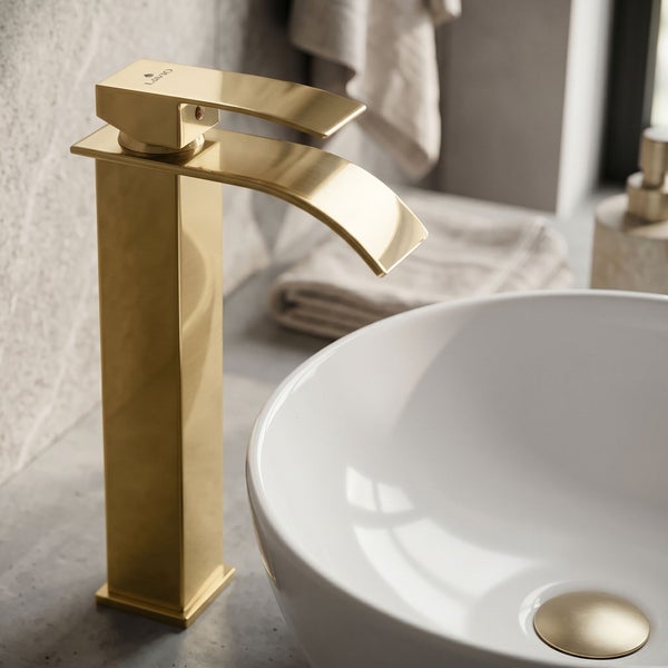 Goldene Waschtischarmatur mit hohem, gebogenem Auslauf neben einem weißen Aufsatzwaschbecken in einem hellen, modernen Badezimmer.
