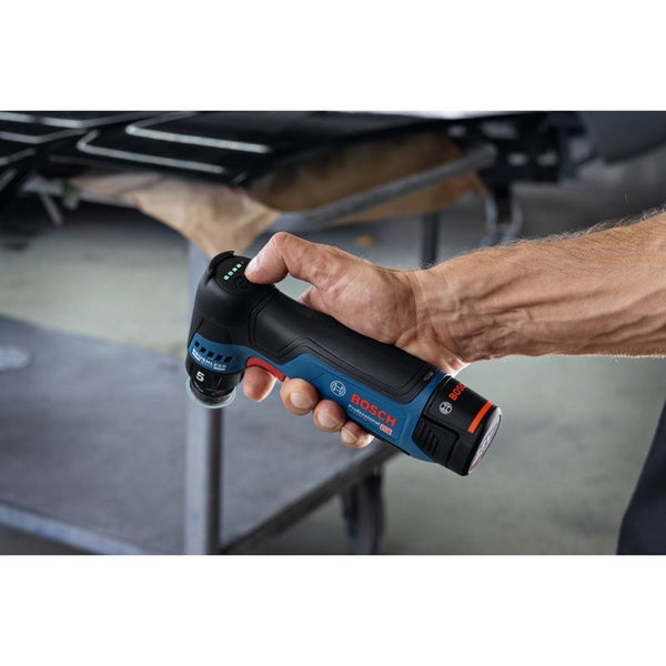 Eine Hand hält einen kabellosen Bosch Professional Akku Winkelschleifer während des Betriebs in einer Werkstattumgebung.