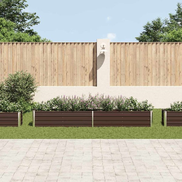 Helle, organisierte Gartenszene mit langen Hochbeeten aus Metall, bepflanzt mit Blumen, auf einem Rasen vor einem Holzzaun und einer Steinterrasse.