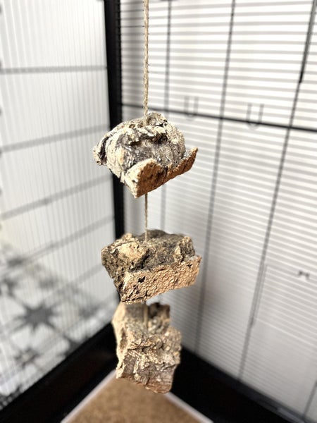 Hängendes Vogelspielzeug oder Nagierspielzeug aus drei Stücken Naturkork an einer Schnur in einem Käfig.