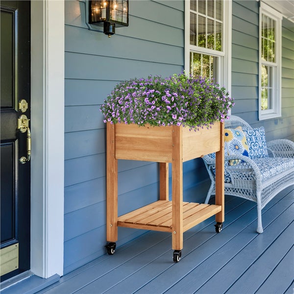 Hochbeet aus Holz mit Rädern und Blumen auf einer Veranda