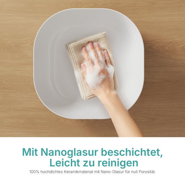 Reinigung eines weißen Waschbeckens aus hochdichter Keramik mit Nanoglasur mit einem Tuch und Schaum.
